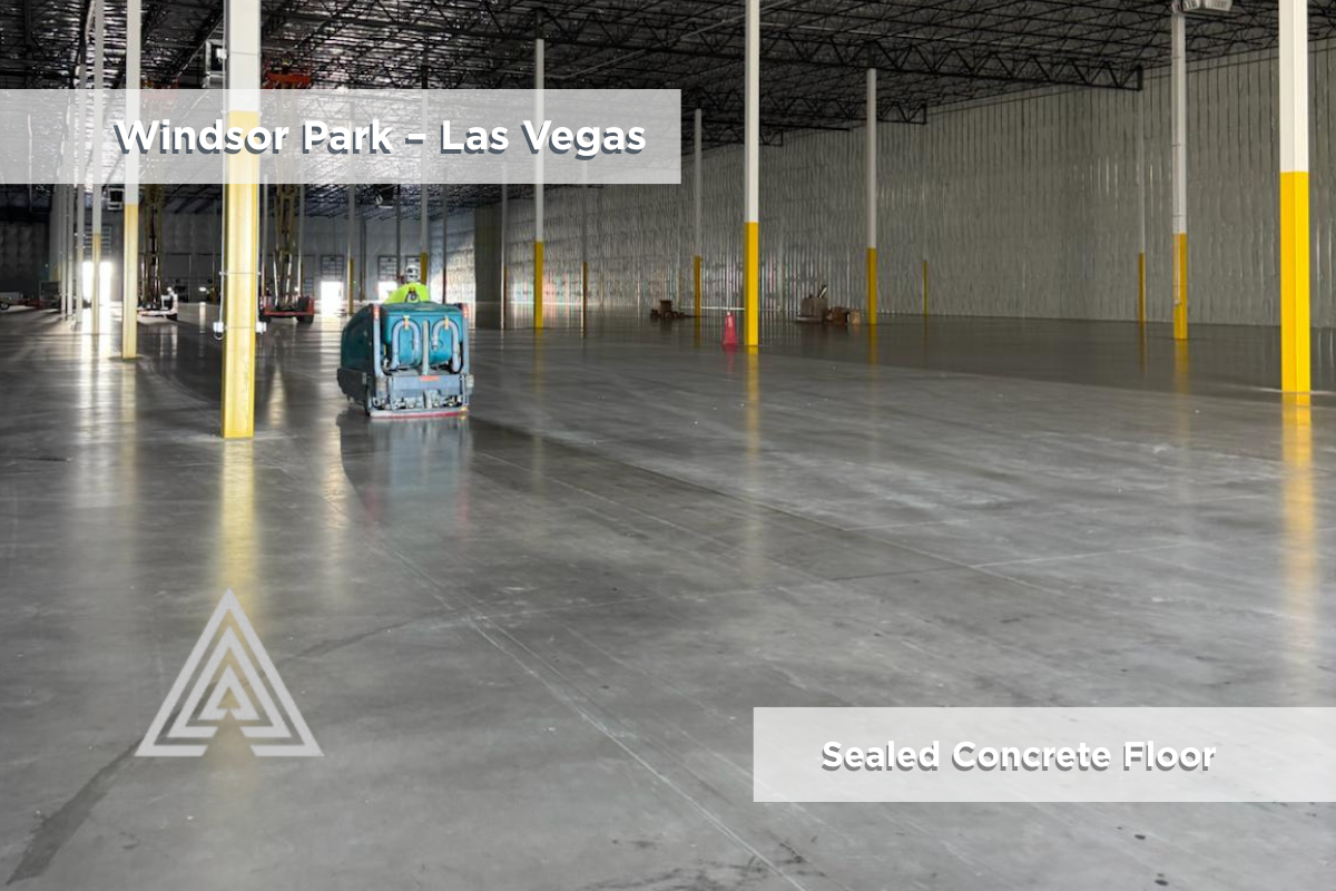 Worker operating ride-on cleaning machine on sealed floor